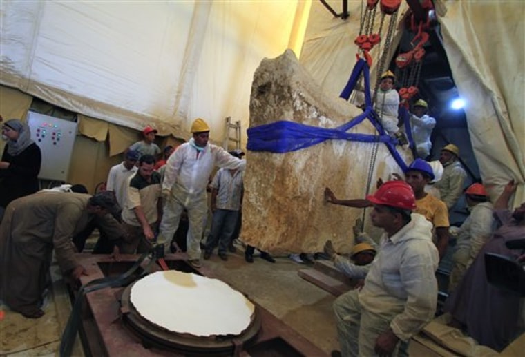 A team of Egyptian and Japanese scientists uses a pulley system to lift the first of 41 16-ton limestone slabs to reveal fragments of the ancient ship of King Khufu next to the Great Pyramid of Giza in Egypt on Thursday.